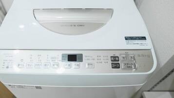 Une machine à laver blanche dotée d’un panneau de commande avec de nombreux boutons et d’un écran numérique.