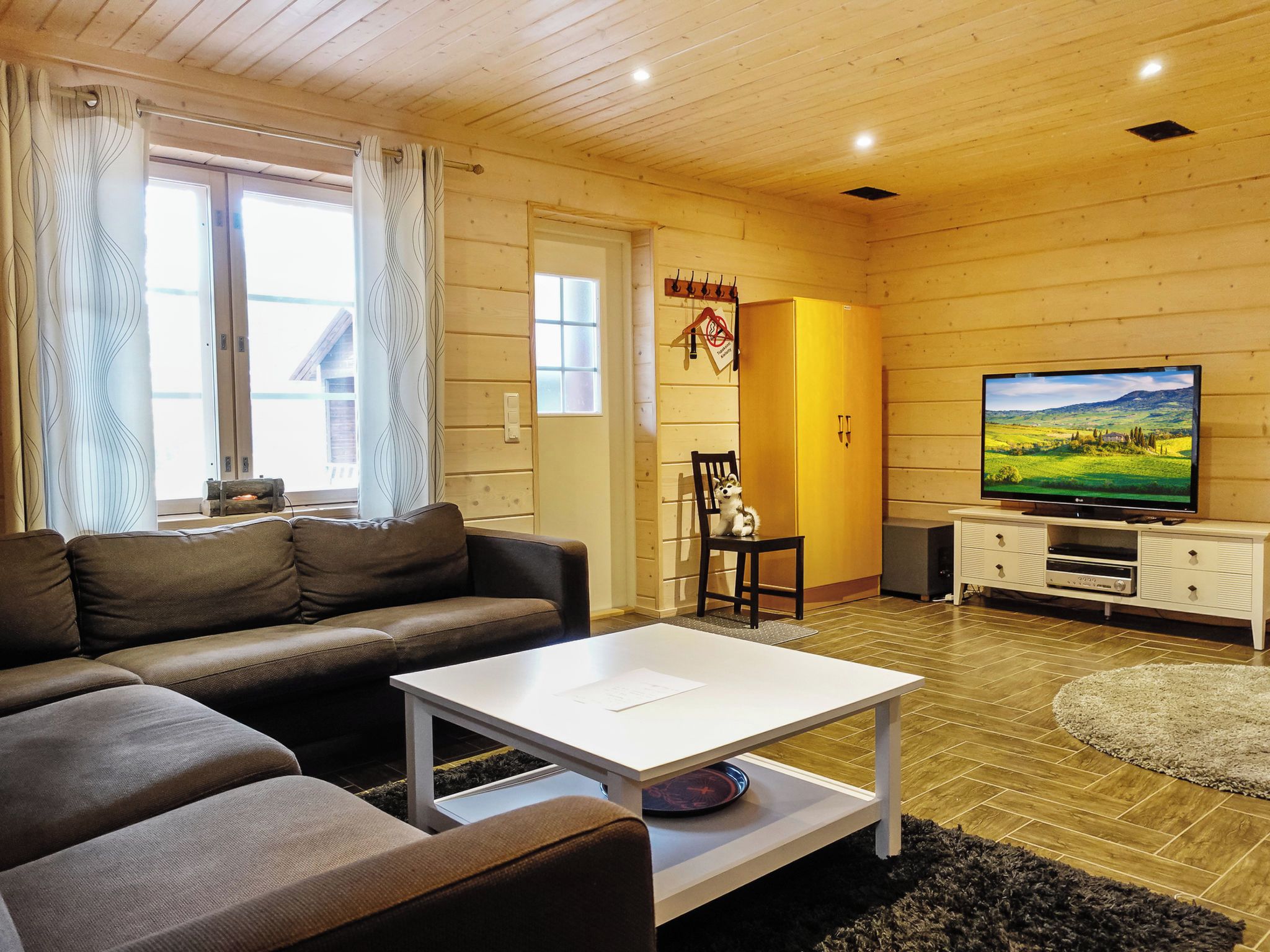A living room with a sofa, a coffee table, a television, and a fireplace.