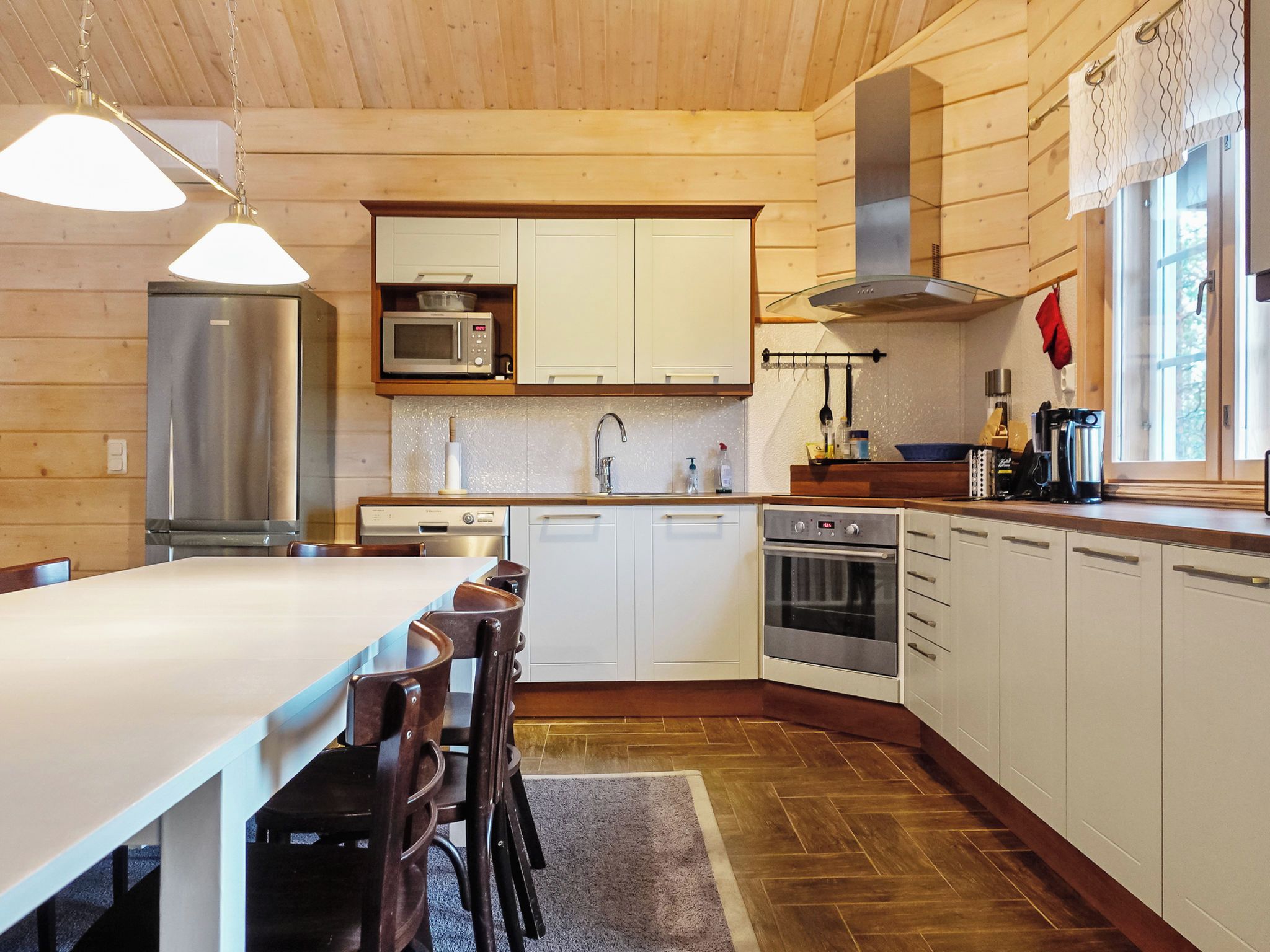 A modern kitchen with white cabinets, stainless steel appliances, and a large island with seating.