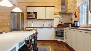 A modern kitchen with white cabinets, stainless steel appliances, and a large island with seating.