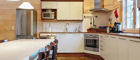 A modern kitchen with white cabinets, stainless steel appliances, and a large island with seating.