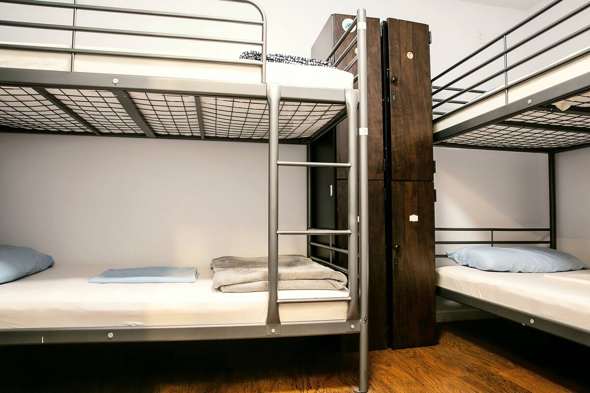 A bunk bed room with a wooden ladder and a metal ladder.