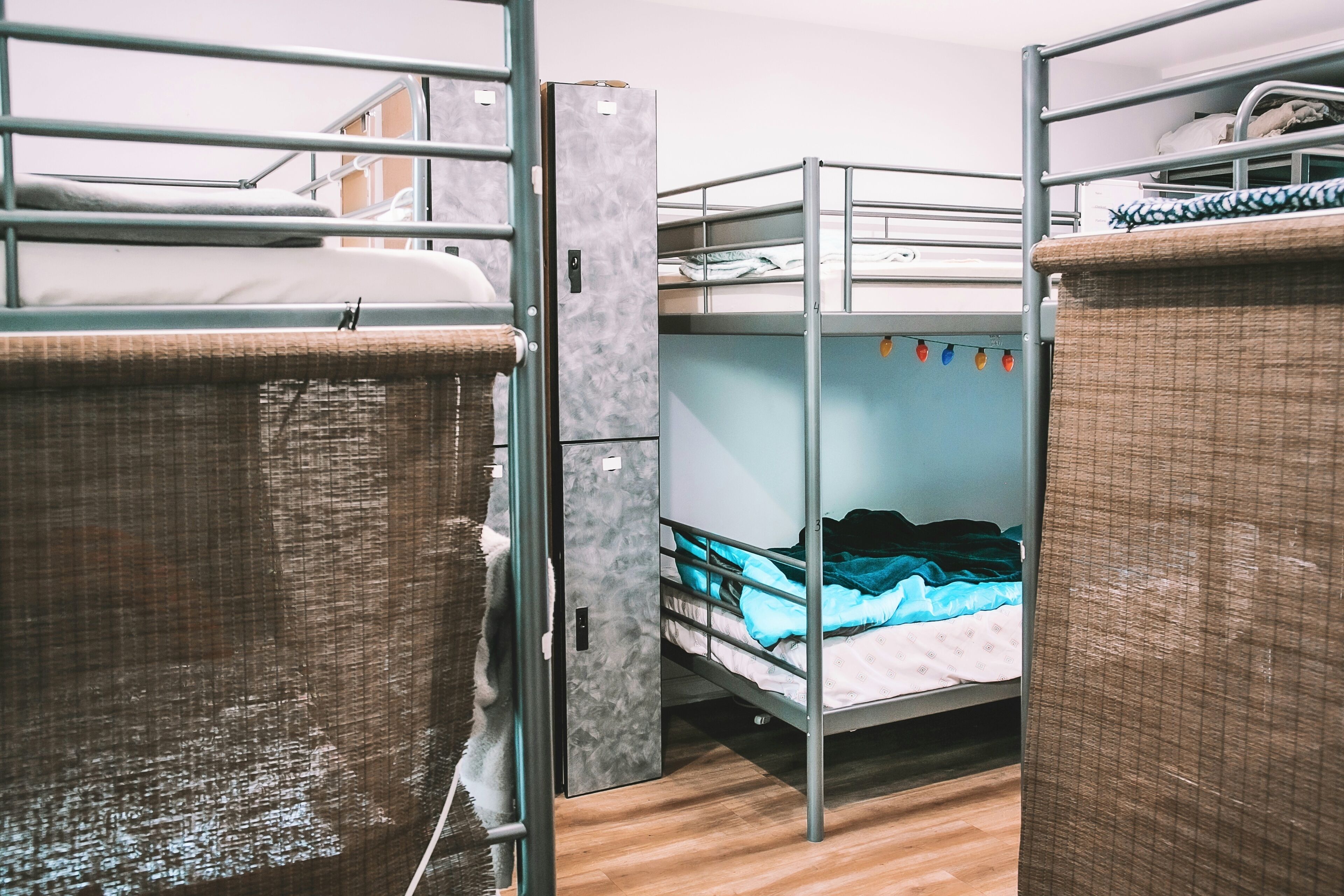 Une chambre avec un lit superposé, une échelle en métal et un plancher en bois.