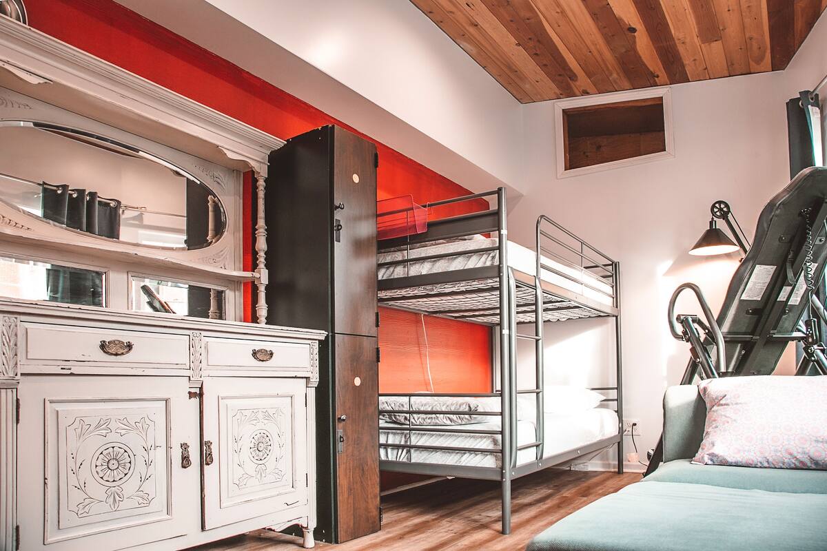 A room with bunk beds, a wardrobe, and a treadmill.
