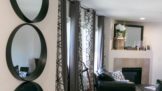 A modern living room with a fireplace, a guitar stand, and three wall-mounted mirrors. - Lynnwood Airport-Retreat (Lynnwood)