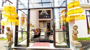 L’entrée d’un hôtel, avec un comptoir d’accueil, des lustres et des statues.
