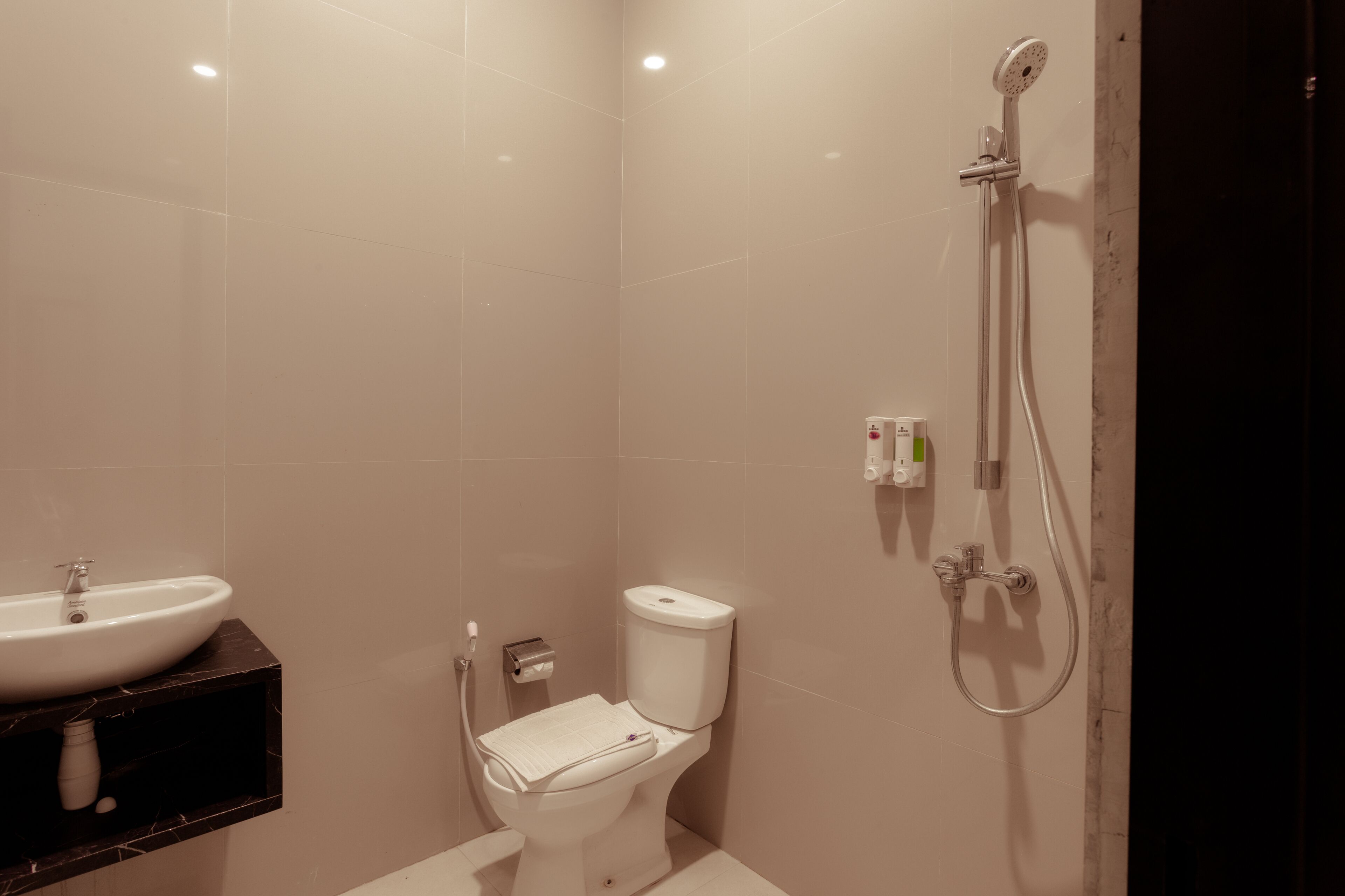 A modern bathroom with a white sink, toilet, and shower.