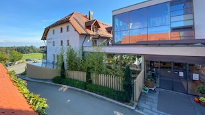 Un bâtiment à deux étages doté d’une façade moderne en verre et d’un toit à deux versants de style traditionnel.