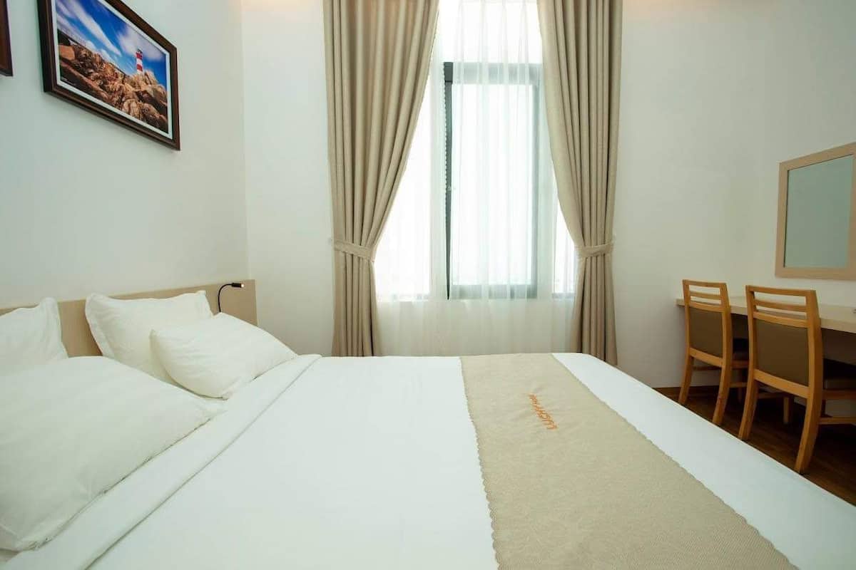 Een hotelkamer met een bed, een bureau en een stoel.