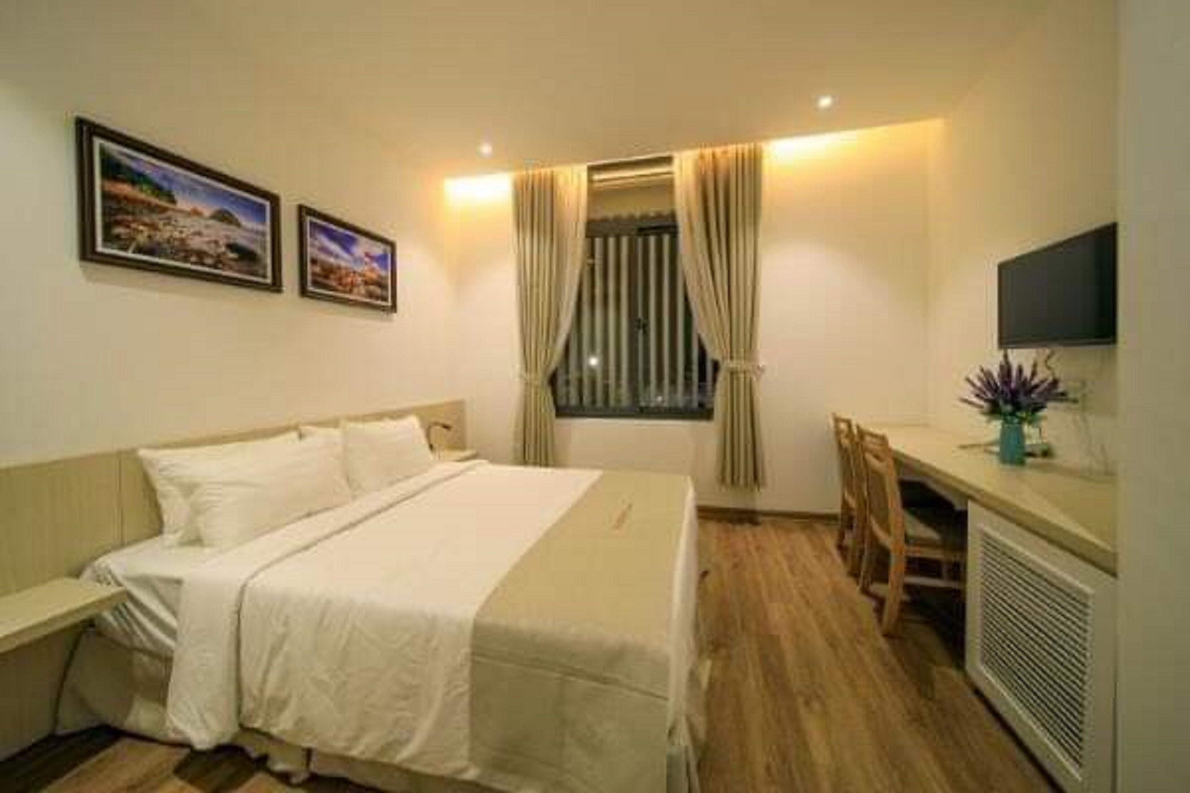 A hotel room with a bed, a desk, and a TV.