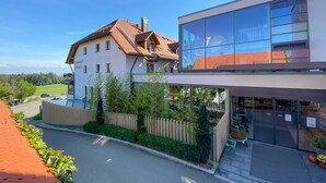 Un bâtiment à deux étages doté d’une façade moderne en verre et d’un toit à deux versants de style traditionnel.