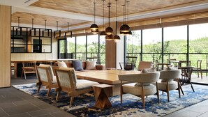 A spacious living area with a large wooden table, multiple chairs, and hanging pendant lights. - Fairfield by Marriott Kyoto Kyotamba (Kyotanba)