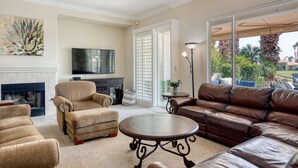 A living room with a fireplace, a television, a sofa, and a coffee table. - Gorgeous Home w/Saltwater Pool/Spa with MISTERS! PGA West - Fabulous Outdoor Setting-3BD#245594 (La Quinta)