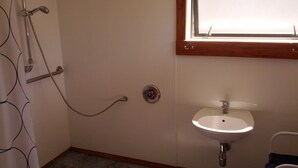 A bathroom with a shower, a sink, and a window. - A comfortable, private, country apartment. 300mts walk to safe sandy beach. (Collingwood)