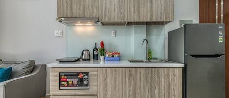 A modern kitchen with wooden cabinets, a built-in microwave, and a stainless steel refrigerator.