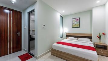 A modern bedroom with a wooden bed, a red accent, a nightstand, and a painting on the wall.