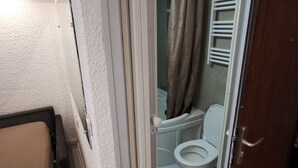 A bathroom with a toilet, a shower curtain, and a towel rack. - Les Effalées (THOLLON LES MEMISES)