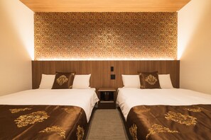 Een hotelkamer met twee bedden, een gestreept plafond en een houten hoofdbord.