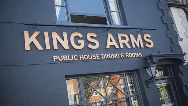 Um edifício com uma placa que diz "KINGS ARMS PUBLIC HOUSE DINING & ROOMS".