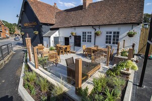 Un pub tradicional con terraza, un letrero que dice "Kings Arms" y fachada de ladrillo.