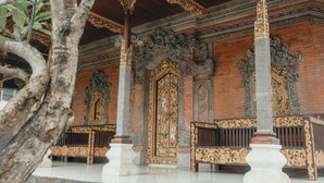 An ornate wooden structure with intricate carvings and a polished floor. - Hotel Diana 2 (Denpasar)