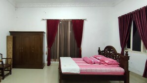 A bedroom with a bed, a wardrobe, a desk with a radio, and a chair. - Penginapan Pendopo Kasih (Semin)