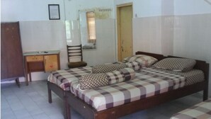 A bedroom with a double bed, a wooden desk, and a chair. - Hotel Indah Syariah (Surabaya)