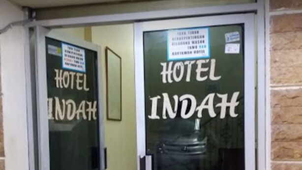A hotel entrance with glass doors and a sign that reads "HOTEL INDAH". - Hotel Indah Syariah (Surabaya)