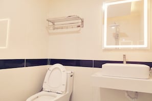 A bathroom with a toilet, sink, and a towel rack.