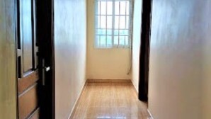 A hallway with a tiled floor, a window with bars, and a door on the left. - Cuc Phuong Hotel (Ho Chi Minh City)