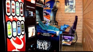 A room with a gaming arcade, a Coca-Cola vending machine, and a poster on the wall. - Vibrant Vacay - Studio Loft for 4 with Deck, Wifi, Hot Tub & Pools (Gatlinburg)