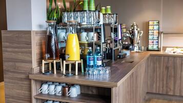 Una zona de bar con estantes llenos de tazas, vasos y botellas.