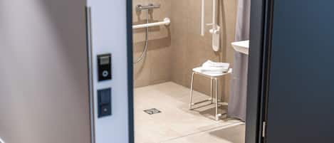 A modern bathroom with a shower, a toilet, and a sink.