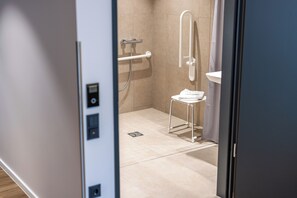 Een moderne badkamer met een douche, toilet en wastafel.