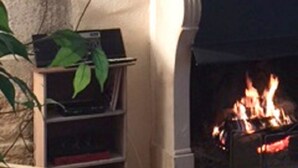 Una chimenea con pared de ladrillo y un televisor montado encima.