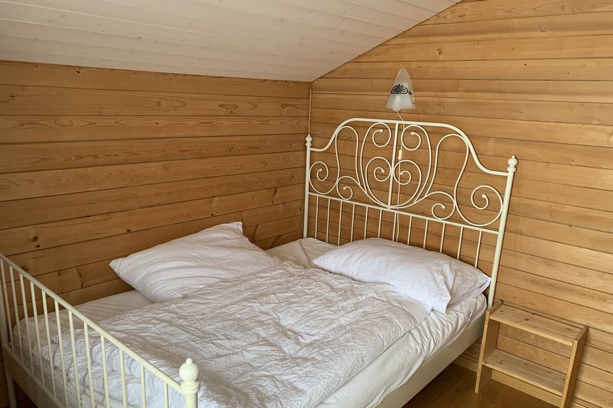 A single bed with a metal headboard and a wooden nightstand.