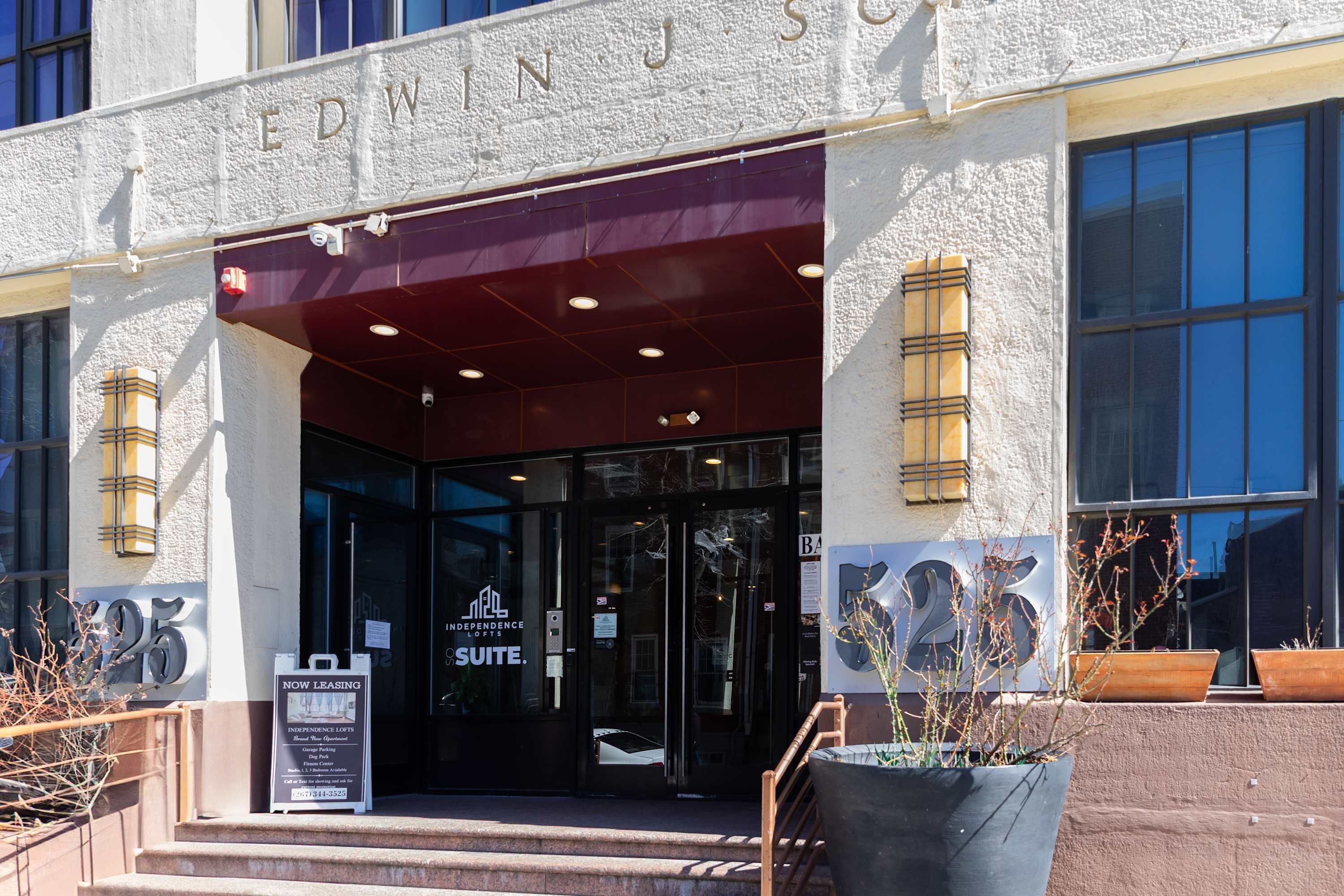 A building entrance with a sign for 'EDWINS SUEIT' and a 'NOW LEASING' sign.