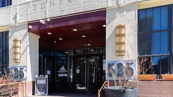 A building entrance with a sign for 'EDWINS SUEIT' and a 'NOW LEASING' sign.