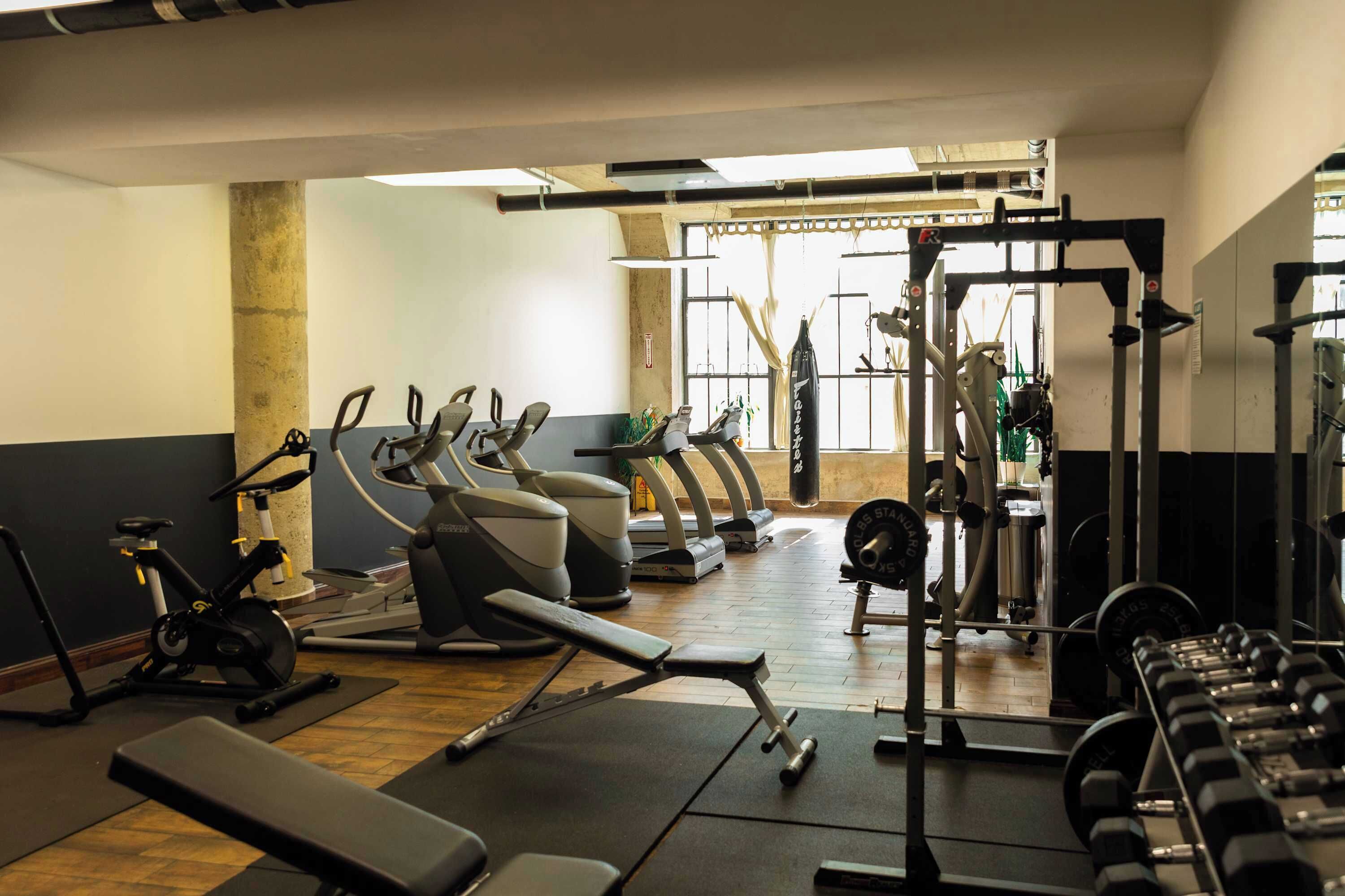 A gym with exercise equipment, including treadmills, stationary bikes, and weight machines.