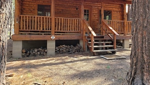 A rustic log cabin with a wooden porch and a staircase leading to the entrance. - Circle Pine Ranch-"The Real Log Cabin Experience" (Alpine)