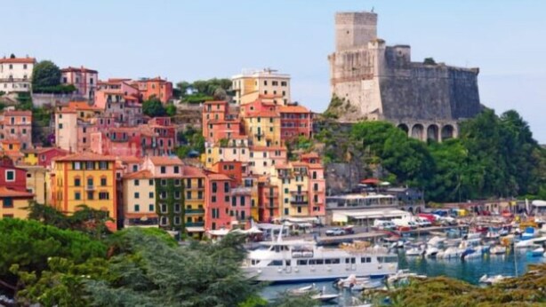 A coastal town with colorful buildings, a historic tower, and a marina with boats. - Blue view, blue bay, lerici (lerici)