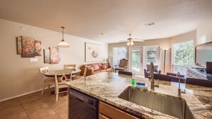 A kitchen with a granite countertop, a dishwasher, and a dining area with a table and chairs. - Dreams And Streams Ww H303 3 Bedroom Condo by RedAwning (New Braunfels)