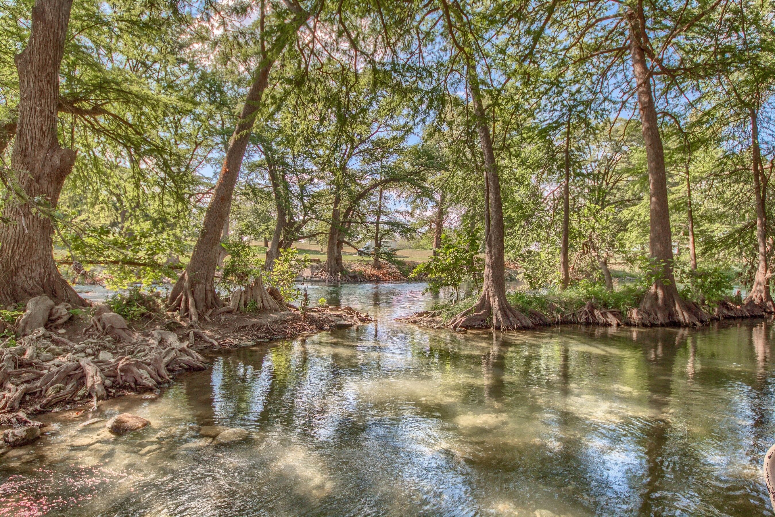 Un área boscosa y tranquila, con un río apacible rodeado de árboles y paisajes naturales.