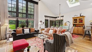 A spacious living room with a large window, a fireplace, and a dining area. - Enclave 158 4 Bedroom Home by RedAwning (Avon)