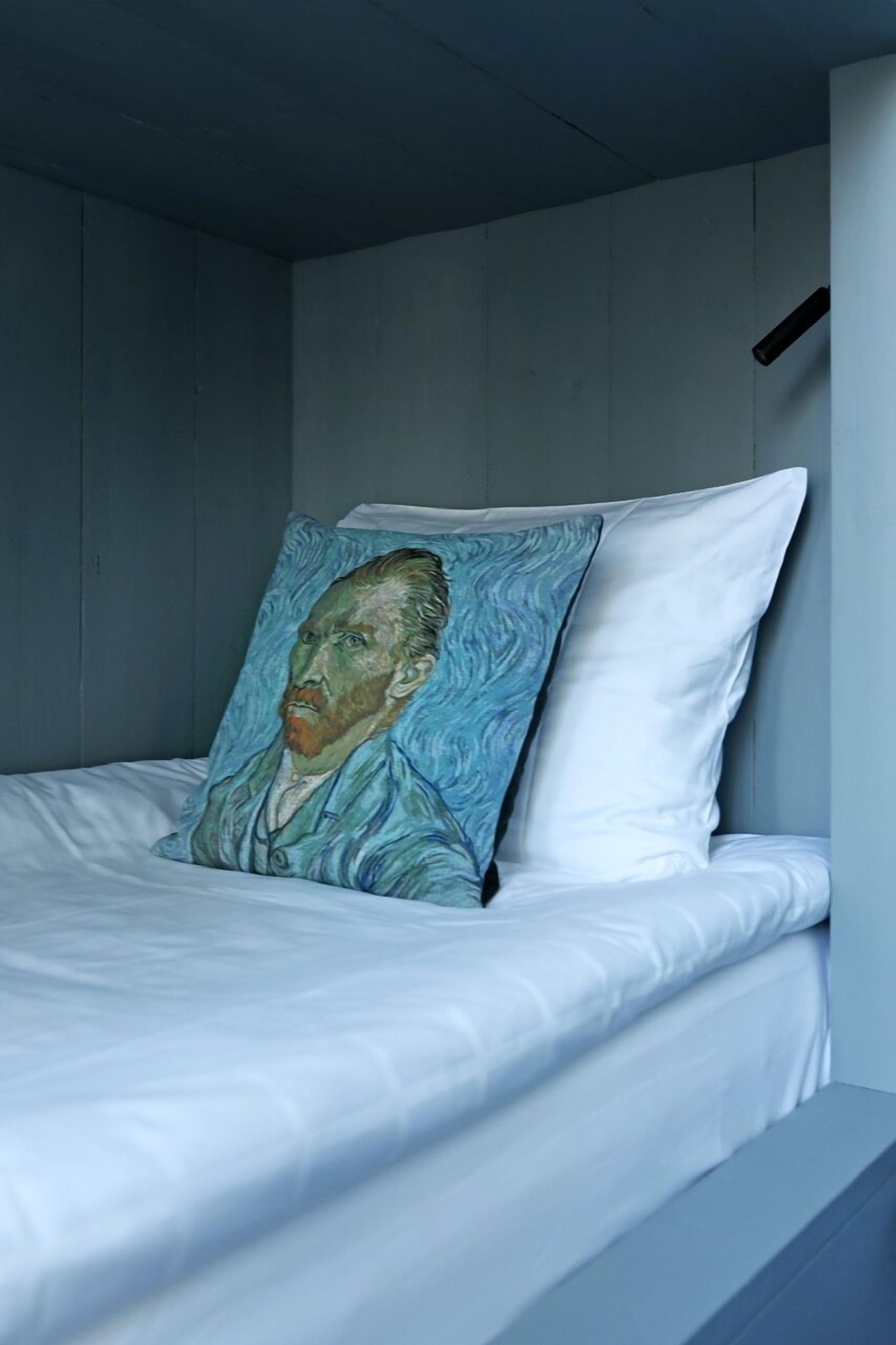 Een stapelbed met een kussen waarop een portret is afgebeeld.