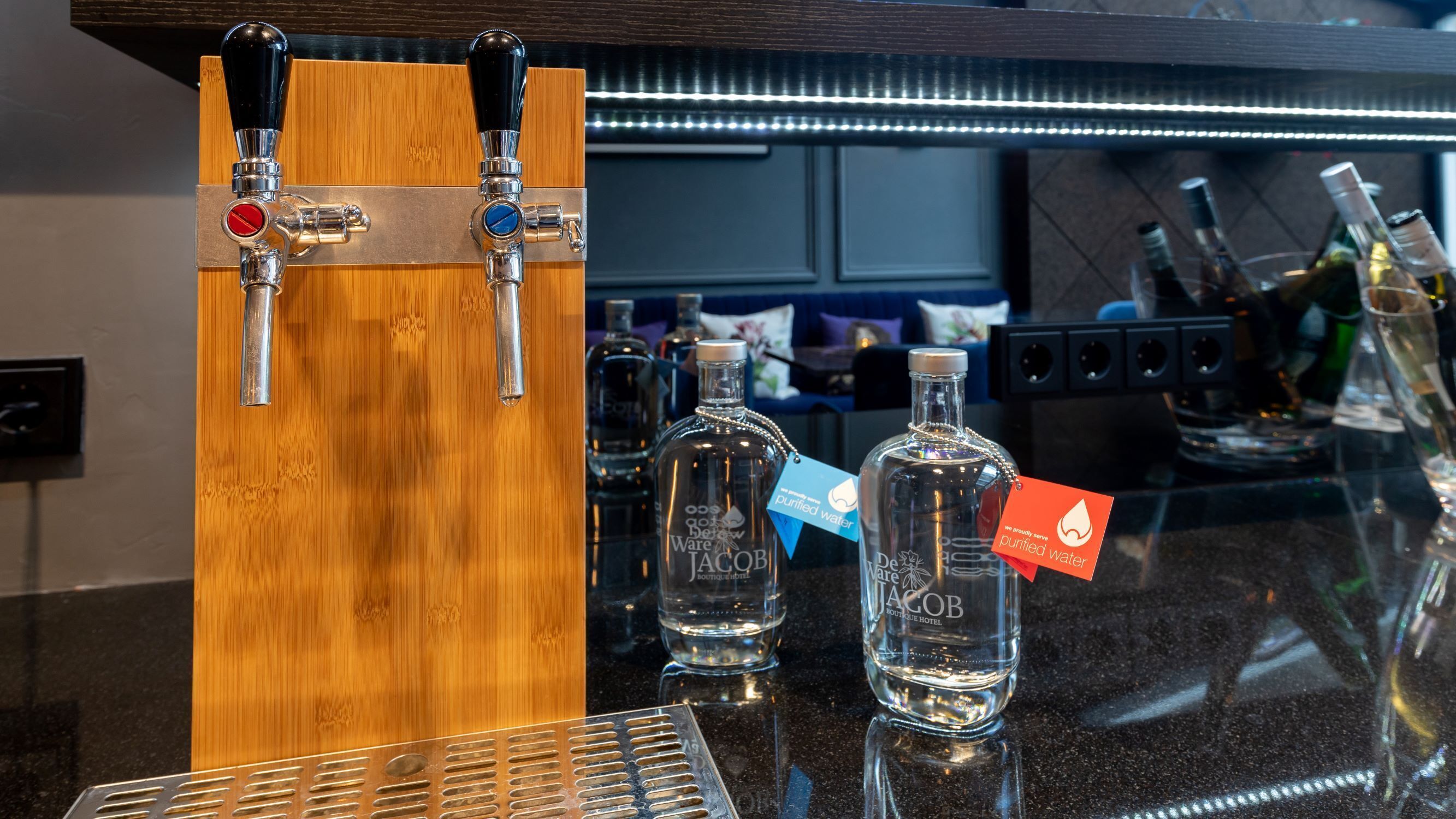 Un coin bar avec deux robinets, une bouteille de liqueur Jacob's et une bouteille de liqueur De la Jacob's posées sur un comptoir.