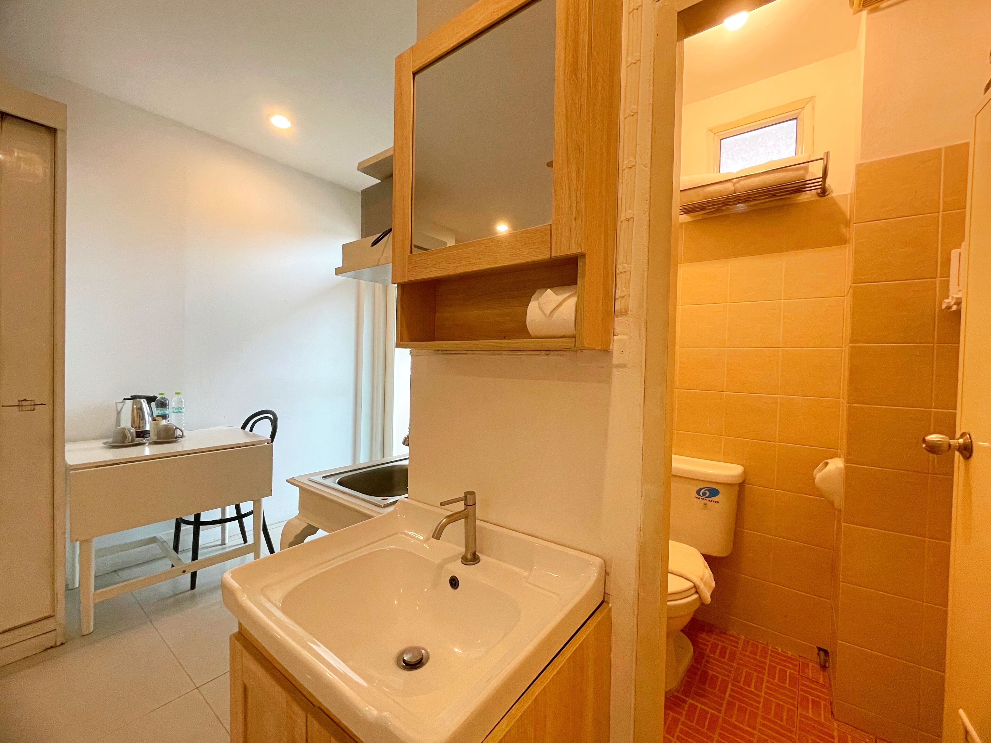 A bathroom with a sink, toilet, and mirror.