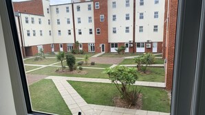 A courtyard with a building in the background. - Toothbrush Apartments - Ipswich Nr Train - Ranelagh Rd (Ipswich)