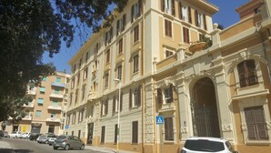 Un edificio de varios pisos con arquitectura clásica, que cuenta con balcones y ventanas amplias.