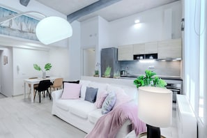 Relax in a spacious living area with a sofa, dining table, and kitchenette.